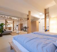 A bright bedroom in a 3-room apartment with a bed, plants, and an open space.