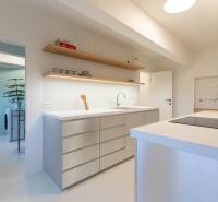 A kitchen in a 3-room apartment with a modern island and open storage space.