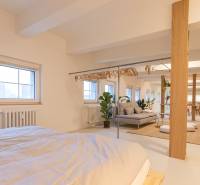 Spacious interior of a 3-room apartment with a bed, coat racks, and a sofa set.