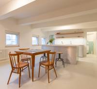 A bright kitchen in a 3-room apartment with wooden chairs and a table, white floor.