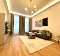 Living room of a two-room apartment with a wooden decor floor and stylish lighting.