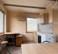 A kitchen with a dining area and a wooden decor floor in a cozy cabin.