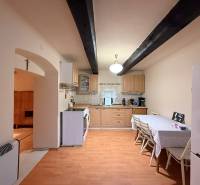 A kitchen in a cabin with a table, chairs, and a wooden-patterned floor.