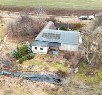A cottage on Zánemecká in Hriňová with a meadow, trees, and solar panels on the roof.
