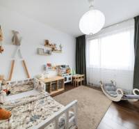 Children's room in a 3-room apartment with toys and a bed, floor with wooden decor.