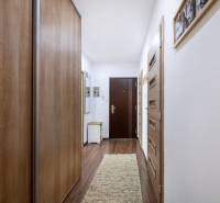 A hallway in a 3-room apartment with a wooden decor floor and built-in wardrobes.