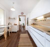 A kitchen in a 3-room apartment with white cabinets and a wood-patterned floor.