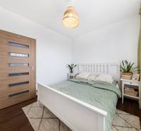 Bedroom in a 3-room apartment with a bed, nightstand, and floor with wood decor.
