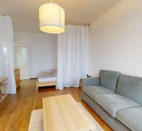 Living room in a three-room apartment with a wooden decor floor and a comfortable sofa.