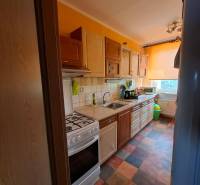 A colorful kitchen with a gas stove and flooring in a multi-room apartment.