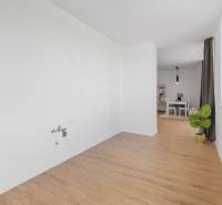 Interior of a 3-room apartment with a wooden decor floor and a dining area.