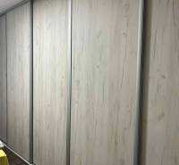 Sliding wooden wardrobe with a floor featuring a wooden decor in a 3-room apartment.