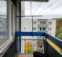 A balcony with a view of greenery and an apartment building in the 1. Mája housing estate, Vranov nad Topľou.