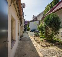 Courtyard between buildings on Obchodná Street in Bratislava - Old Town, with parking spaces.