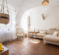 Living room in a studio apartment with a light sofa and a wooden decor floor.