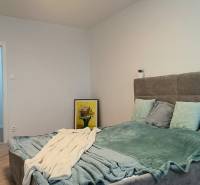 Bedroom in a 4-room apartment with a soft bed and decoration. Floor with wooden decor.