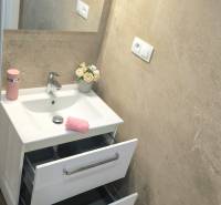 Bathroom with a mirror, sink, open drawers, and decorative roses in a 4-room apartment.