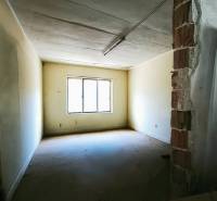 A room in a production area with a window, yellow walls, and an exposed brick section of the wall.