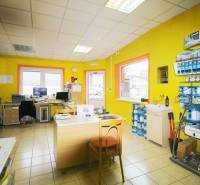 Interior of production facilities with yellow walls, office furniture, and shelves with paints.