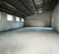 Spacious production facilities with concrete floors and large windows.