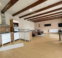 Interior of a family house with a kitchen, wooden decor flooring, and a living area.