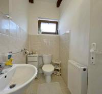 Bathroom in a family house with a sink, toilet, and radiator.