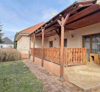 A family house on Hodská in Galanta with a terrace and garden, surrounded by greenery and paving.