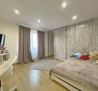 Children's room in a family house with a wooden decor floor and toys on the bed.