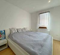 Bedroom in a family house with a bed, a painting, and a wooden decor floor.