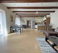 A family house with a wooden decor floor, a dining table, and a sofa set.