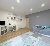 Interior of a family house with a writing desk, television, and wooden decor flooring.