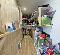 Narrow storage spaces in a family house with shelves full of clothes and toys.