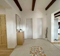 Interior of a family house with ceramic tiles and wooden decor flooring, visible beams.