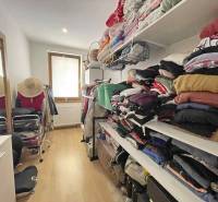 A wardrobe in a family house with a wooden decor floor and shelves for clothes.