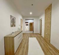 Hallway in a family house with a wooden decor floor and simple furniture.