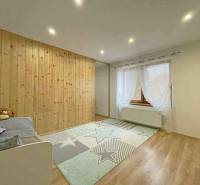 Children's room with a wooden wall, wooden decor flooring, and a decorative carpet.