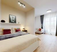 1-bedroom apartment with a bed, sofa, desk, and wood-patterned flooring.