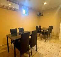 Interior of a gastro space with black chairs and tables on light tiles.