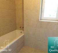 Bathroom with a bathtub and tiles in a 3-room apartment, neutral color tones.