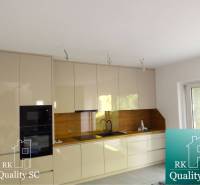 A kitchen in a 3-room apartment with appliances, cabinets, and a wooden decor floor.