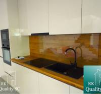 A kitchen in a 3-room apartment with a wooden decor floor and built-in appliances.