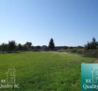 A residential plot on Vrbová Street in Jelka surrounded by greenery and fencing.