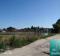 Plots - housing on Vrbová Street in Jelka, enclosed by a wire mesh fence.