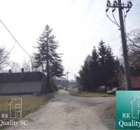 A country road in the Old Port of Gabčíkovo, lined with houses and trees, plots - residential.
