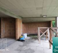An unfinished family house in the stage of rough construction with ceramic bricks and a concrete ceiling.