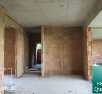 A family house with brick walls and a concrete ceiling, without floor finishing.