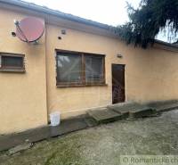 A family house in Neded with a beige facade, satellite, and wooden windows.