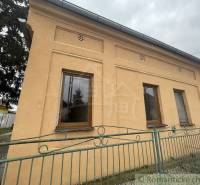 A family house in Neded with a striking yellow facade and a colorful fence.