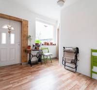 Entrance hall of a family house with a wooden decor floor and a decorative sewing table.