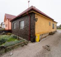 A family house in Bobot on Bobot Street with a stone facade and a yellow container in front of the house.